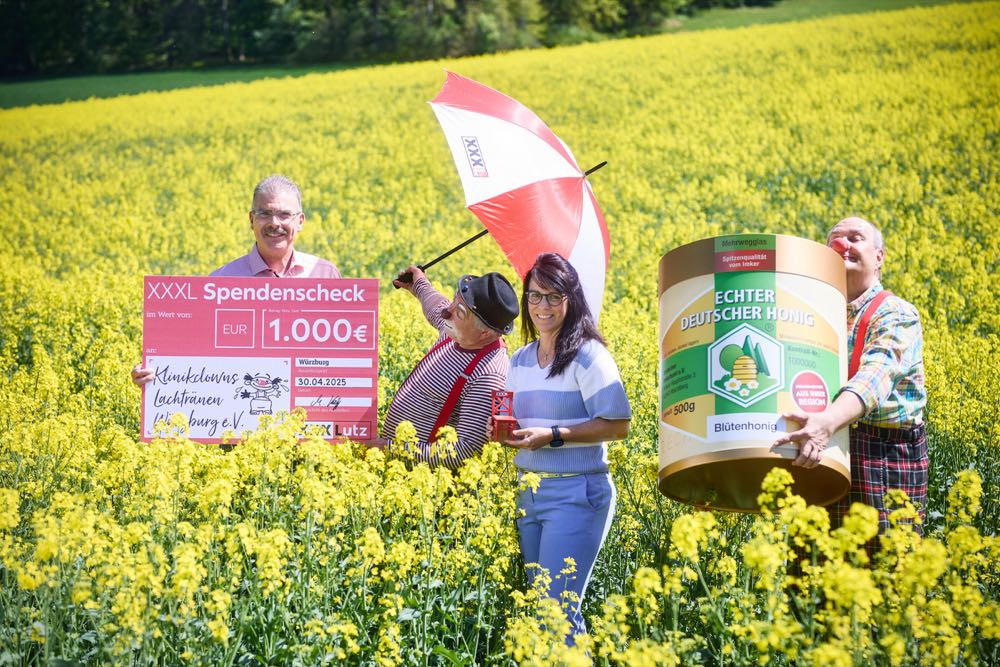Martin Kohlhepp (l.), Gebietsleiter für den Logistikbereich bei XXXLutz, und seine Team-Assistenz Gabriele Leibold übergeben den Spendenscheck an die Klinikclowns. XXXLutz: 1000 Euro-Spende für Klinikclowns